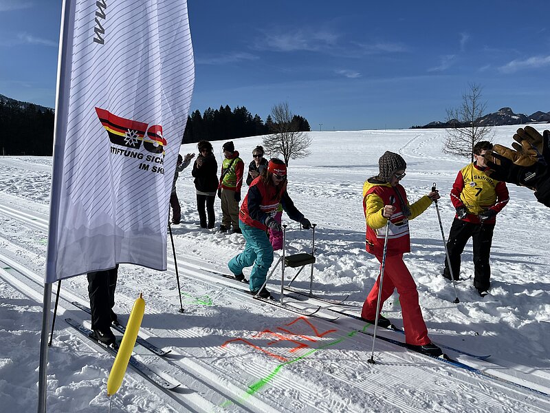 Zieleinlauf von Teilnehmenden der Behinderten Skifreizeit beim Langlaufen