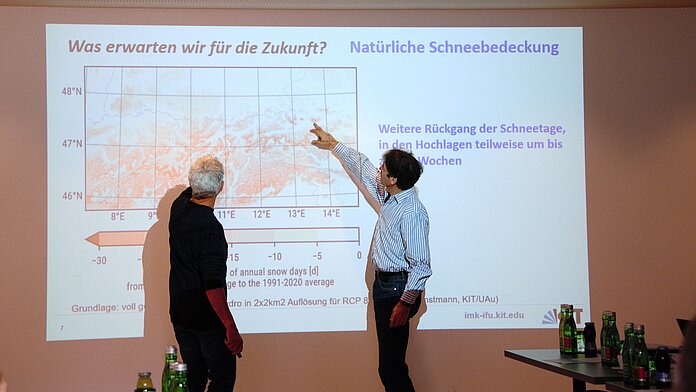 Zwei Wissenschaftler diskutieren im Dialog über eine Graphik zur Klimaentwicklung