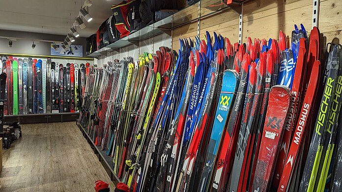Ski aufgereiht an einer Wand in einem Sportfachgeschäft